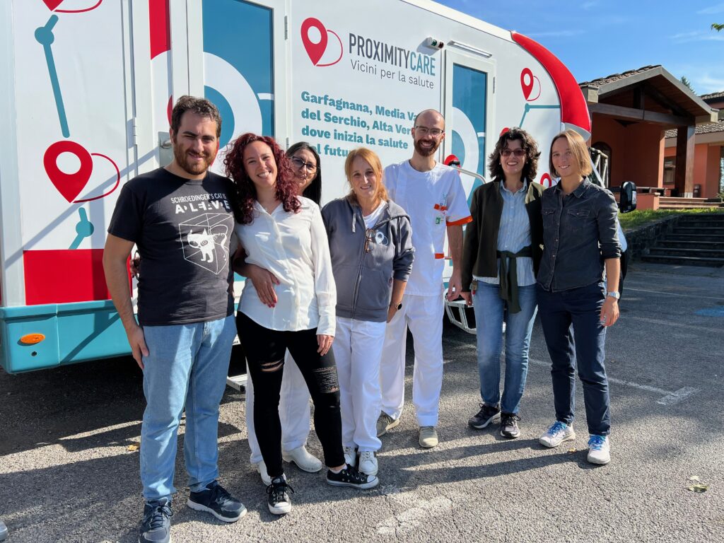 Gruppo di operatori sanitari dell'ASL Toscana Nord-Ovest e ricercatori della Scuola Superiore Sant'Anna posa davanti all'unità mobile di Proximity Care durante i giorni di screening presso il Comune di San Romano per la realizzazione delle attività di prevenzione connesse al modulo Proxy Screening.